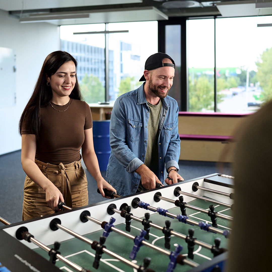 Sebastian Kister plays table football with his colleagues.