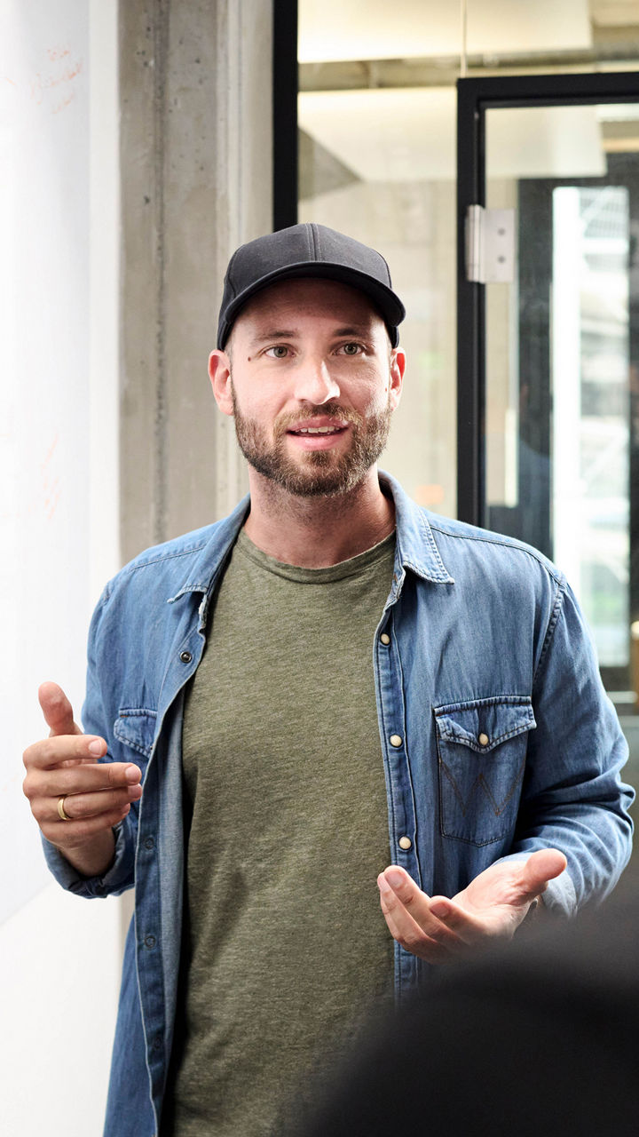Sebastian Kister chats with colleagues and stands next to a sideboard with notes on it