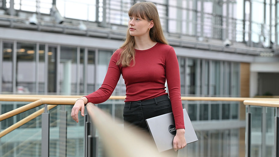 Mädchen ist an ein Geländer gelehnt und steht im Forum eines Gebäudes