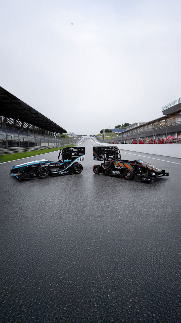 Zwei Formula Student Autos stehen auf einer Rennstrecke