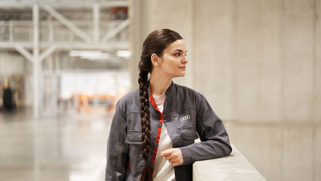 Isabella is leaning against a wall and looking to the right