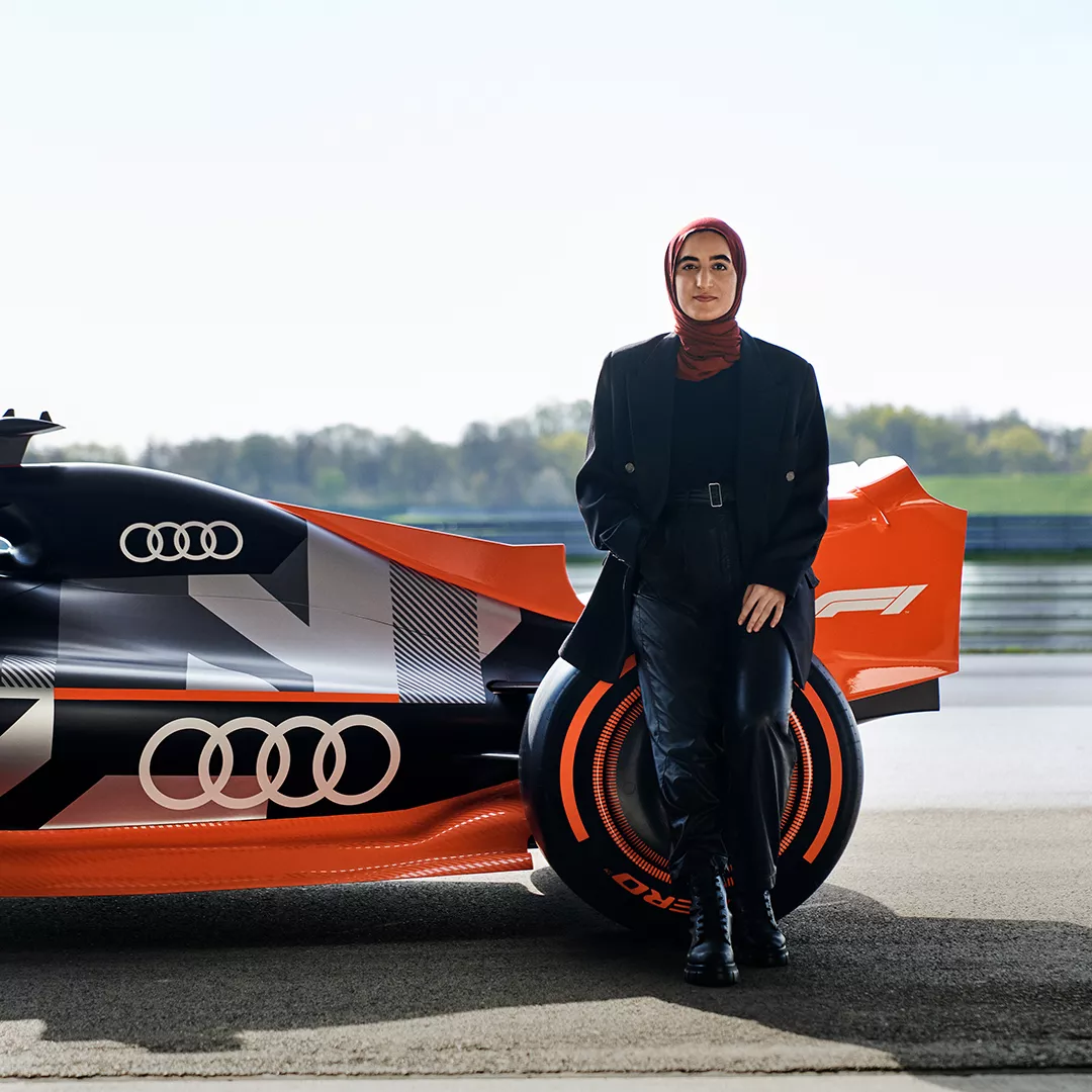 Sümeyye steht an ein Formel 1 Auto von Audi gelehnt