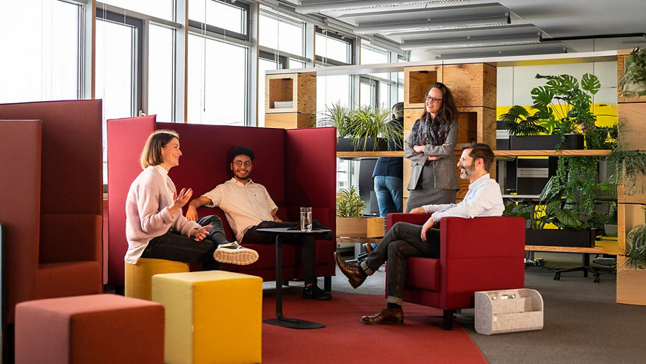 Several employees sit in a circle and talk