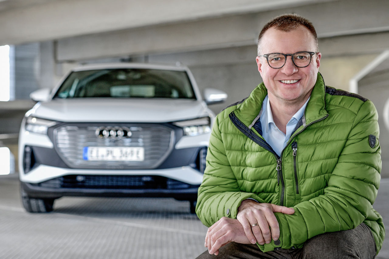 Portrait of Volker Knöll next to an Audi model