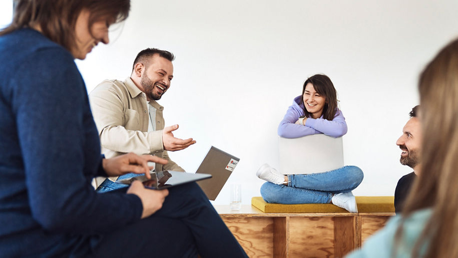 Several employees sit in a circle and talk