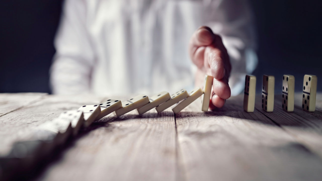 Man holds back a domino