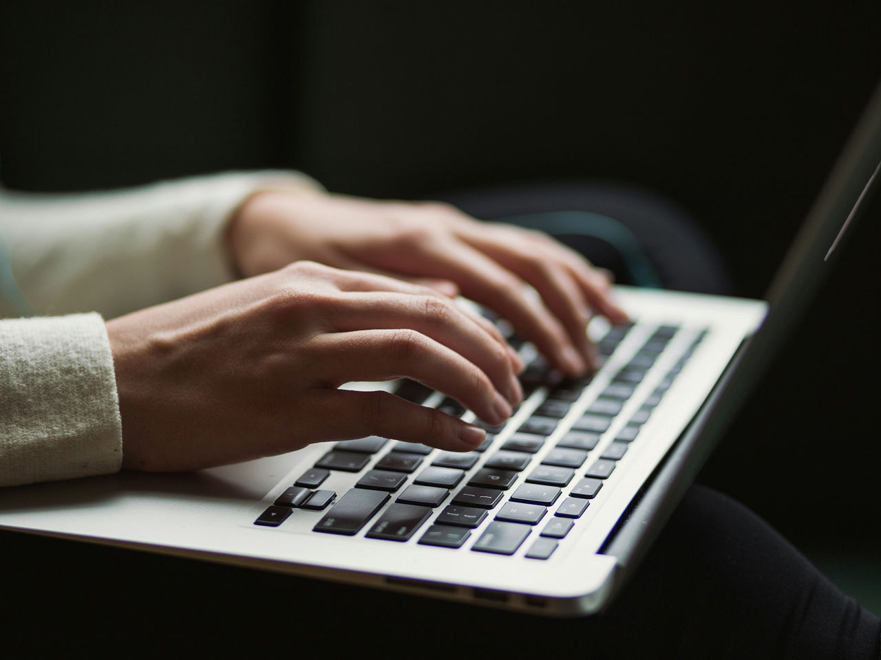 Hände tippen auf einer Laptoptastatur