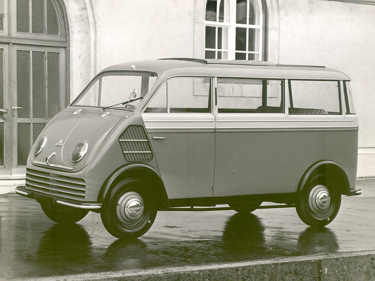 Schwarz-weiß-Aufnahme von einem DKW F 89 L Schnelllaster vor einem Haus