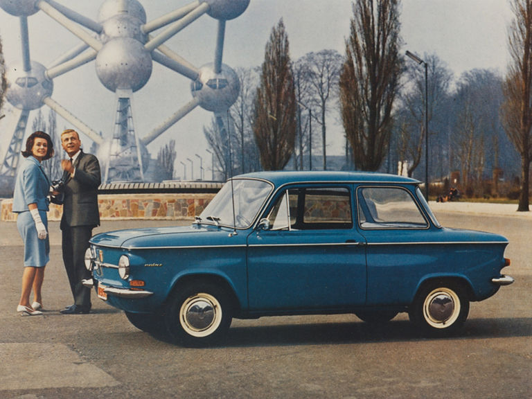 Farbaufnahme eines Paares vor dem Atomium in Brüssel neben einem blauen NSU Prinz