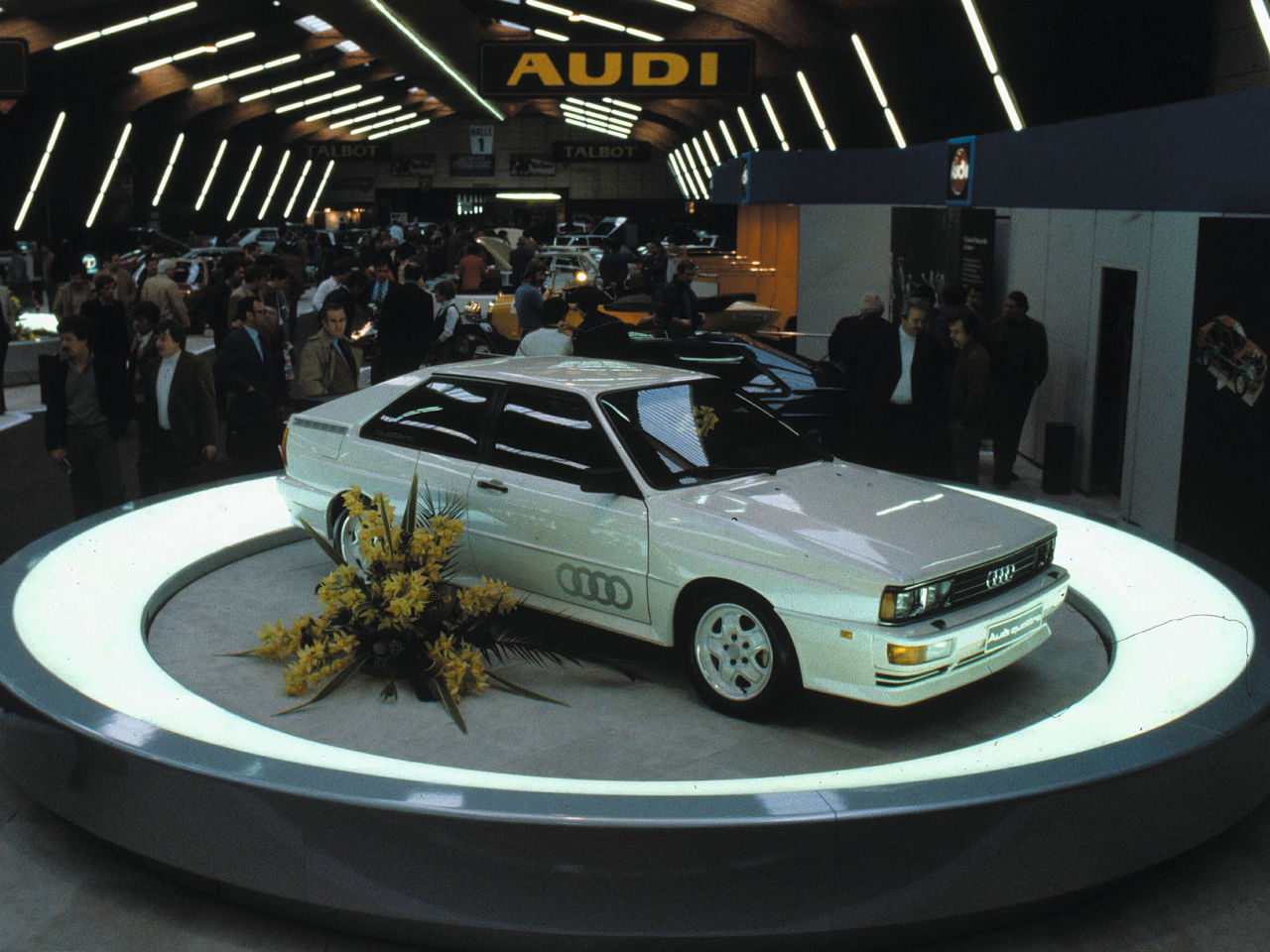 An Audi model is presented on a pedestal at an event