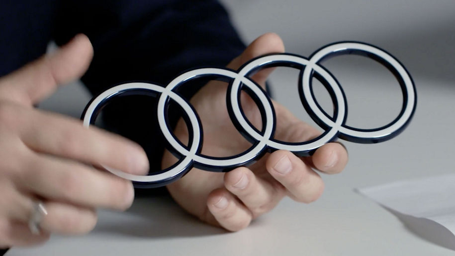 Hands holding an Audi logo as a profile