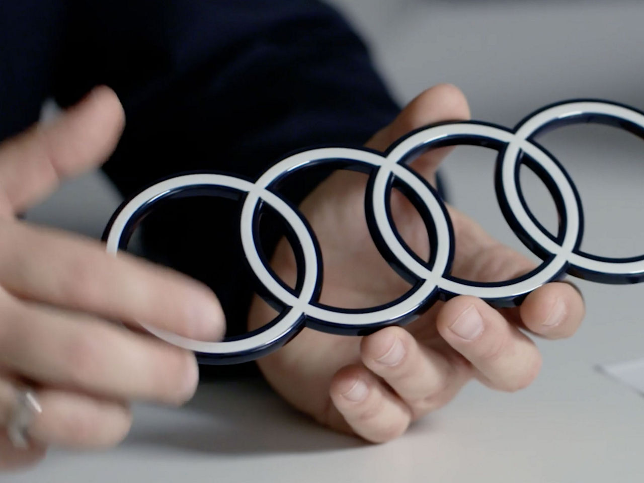 Hands holding an Audi logo as a profile