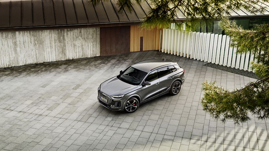 A silver Audi model stands in a courtyard