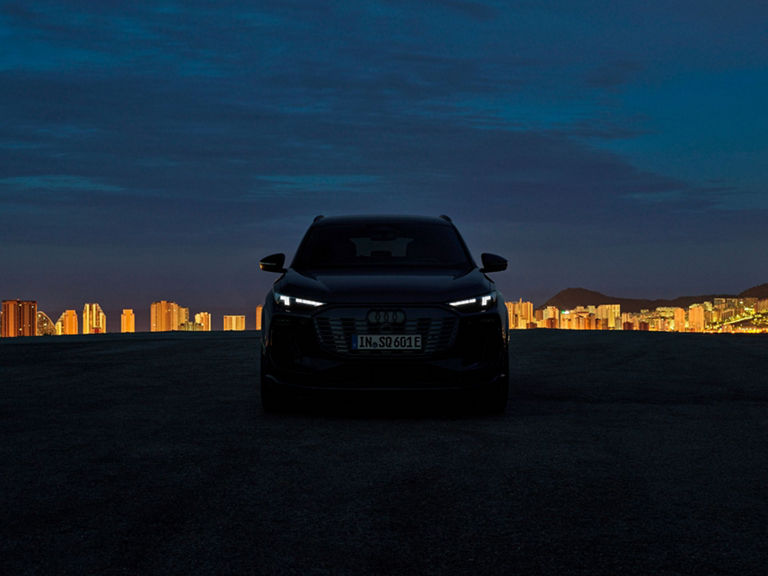Die Scheinwerfer eines Audi Modells leuchten in der Dunkelheit