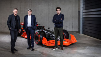 Gernot Döllner, Jürgen Rittersberger and Mattia Binotto stand in front of a red Formula 1 car