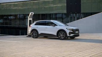 Seitenansicht eines weißen Audi Q4 40 e-tron an einer Ladestation