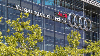 Audi lettering – Vorsprung durch Technik (Advancement through Technology) on the glass wall of a car dealership