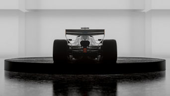 A Ferrari is standing on a black, round platform, with its rear end visible.