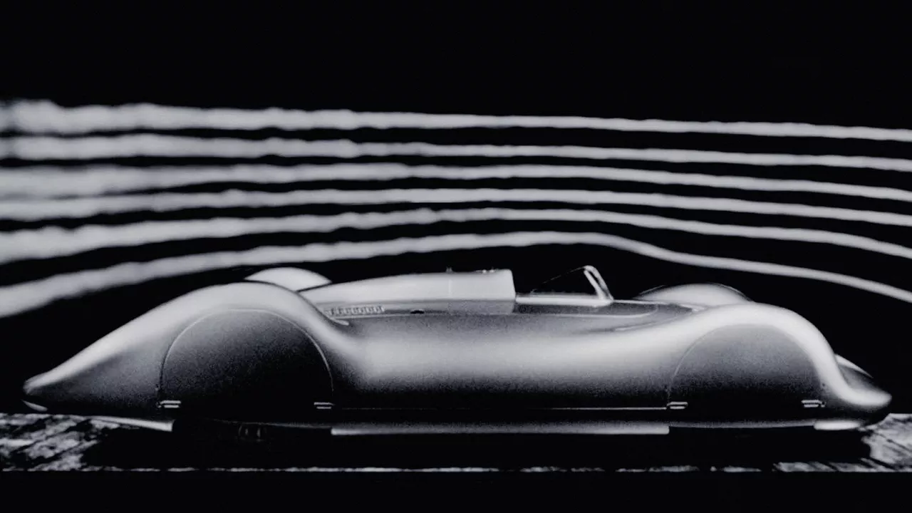 Side view of a fully clad, historic Audi racing car against a dark background. Streamlines are indicated above the vehicle.