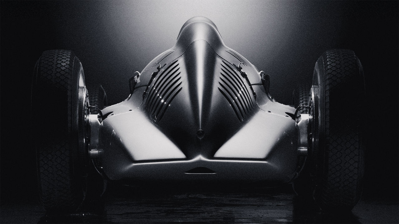 Rear view of a historic Audi racing car against a dark background.