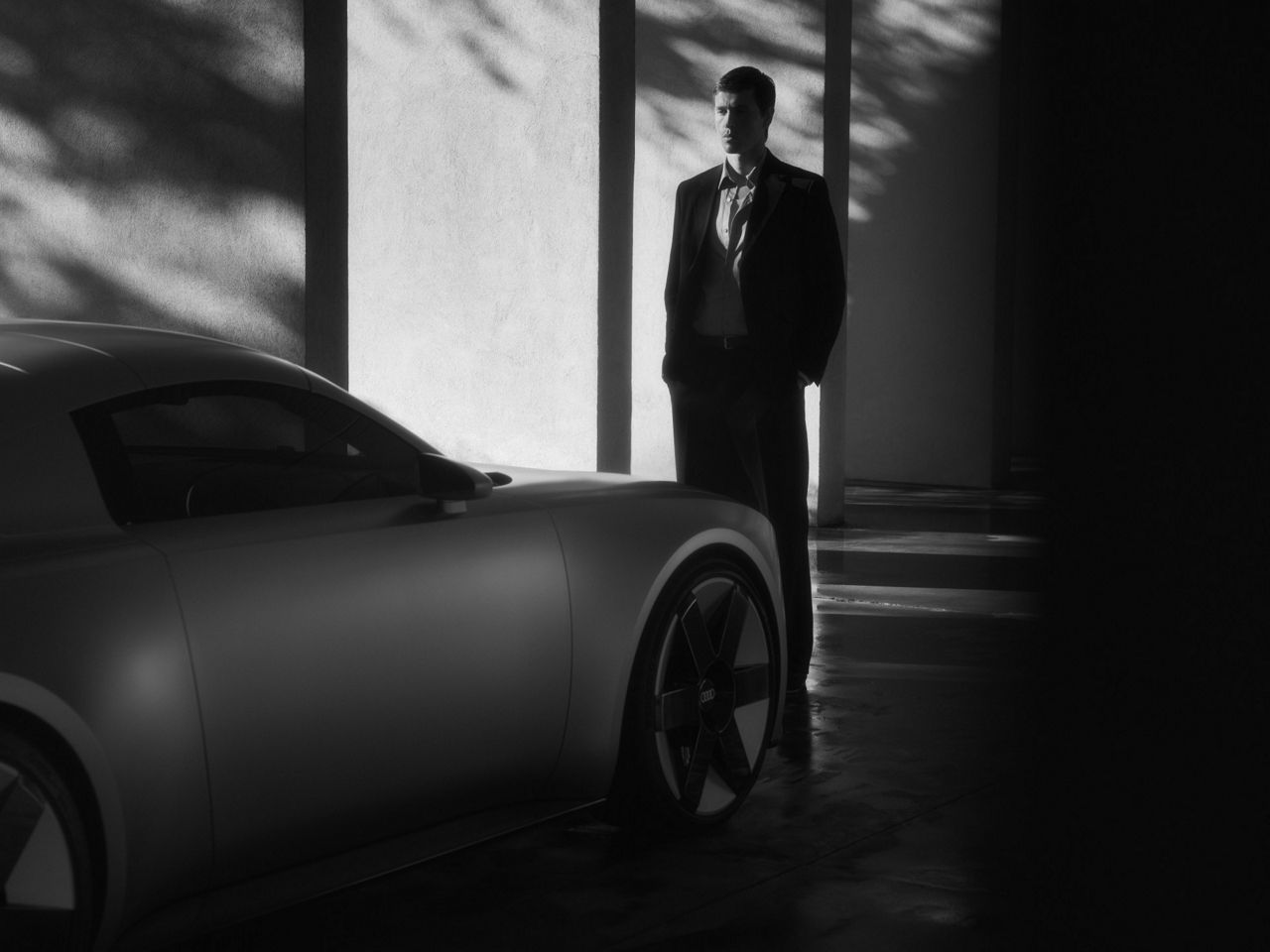 Harris Dickinson walks past the Audi Concept C. The car is seen from the front.