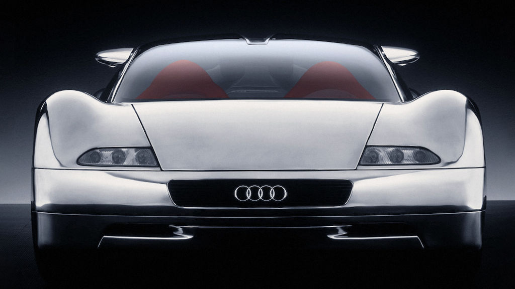 Front view of a historic Audi racing car against a dark background.