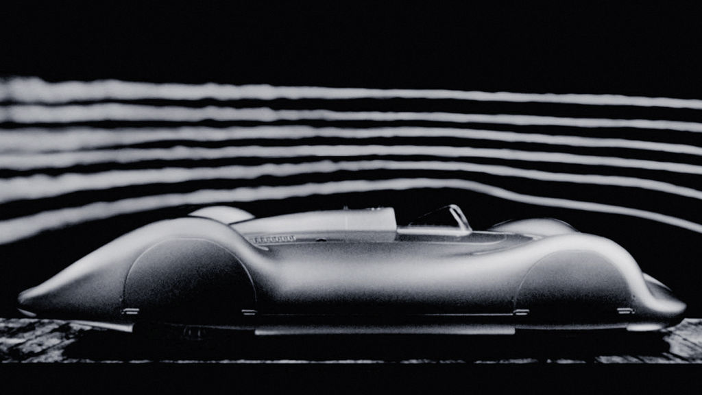 Side view of a fully clad, historic Audi racing car against a dark background. Streamlines are indicated above the vehicle.