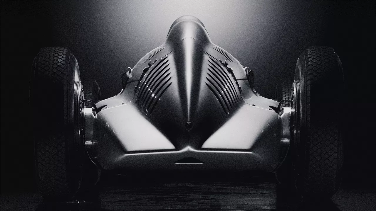 Rear view of a historic Audi racing car against a dark background.