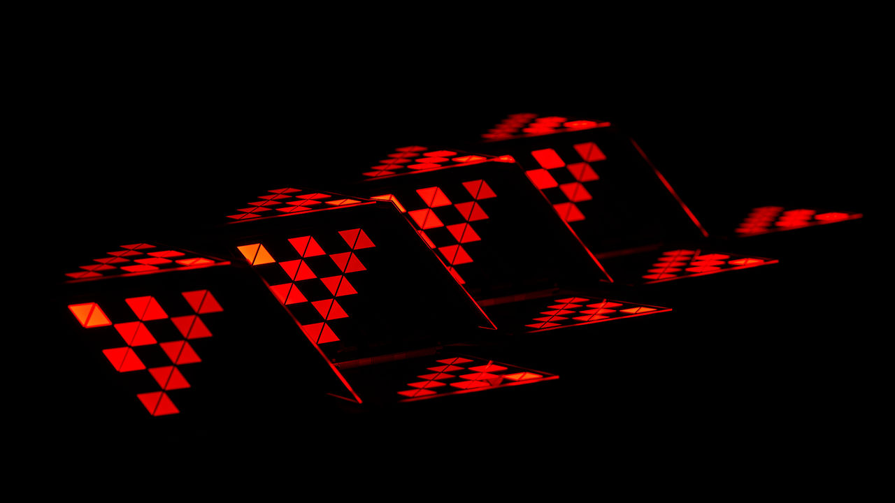 Triangular pattern of LED tail lights on a black background