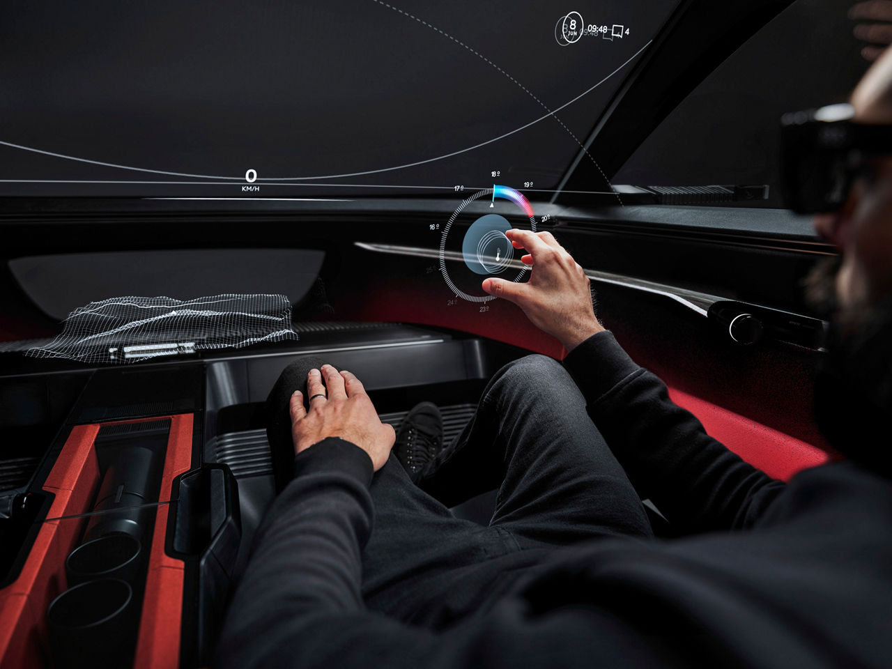 A futuristic vehicle cockpit without physical controls. A driver's hand reaches for a virtual button that floats freely in the air as a hologram.