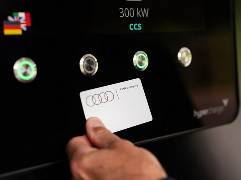 Eine Hand hält eine Audi Charging Karte an die NFC-Fläche beim Charging hub