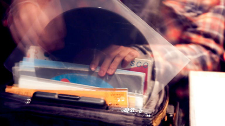 A hand on various books in a bag