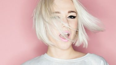 A blonde woman swings her hair