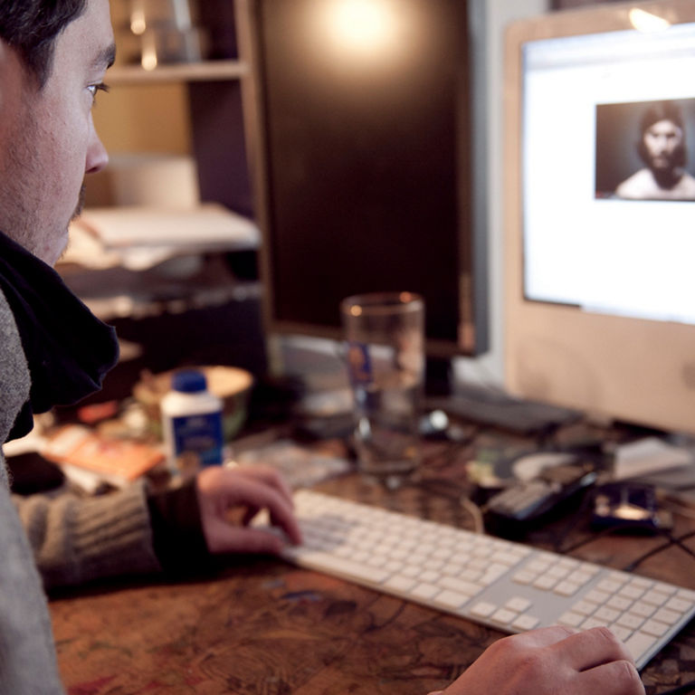 A man sits in front of a computer