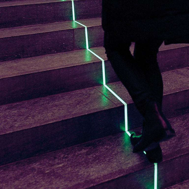 A staircase with a green light strip