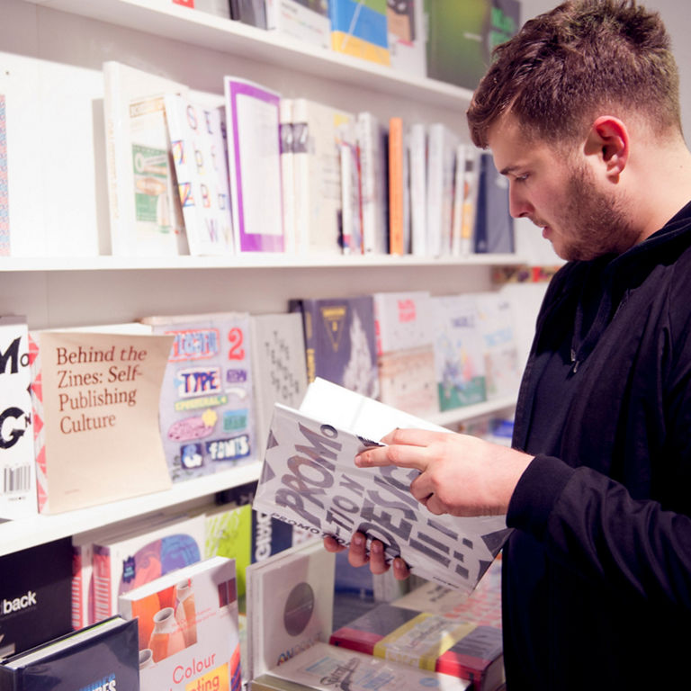 A man looks into a book in front of a book display