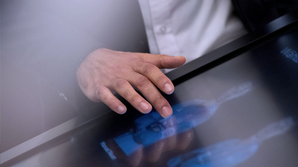 Eine Hand berührt einen Touchscreen