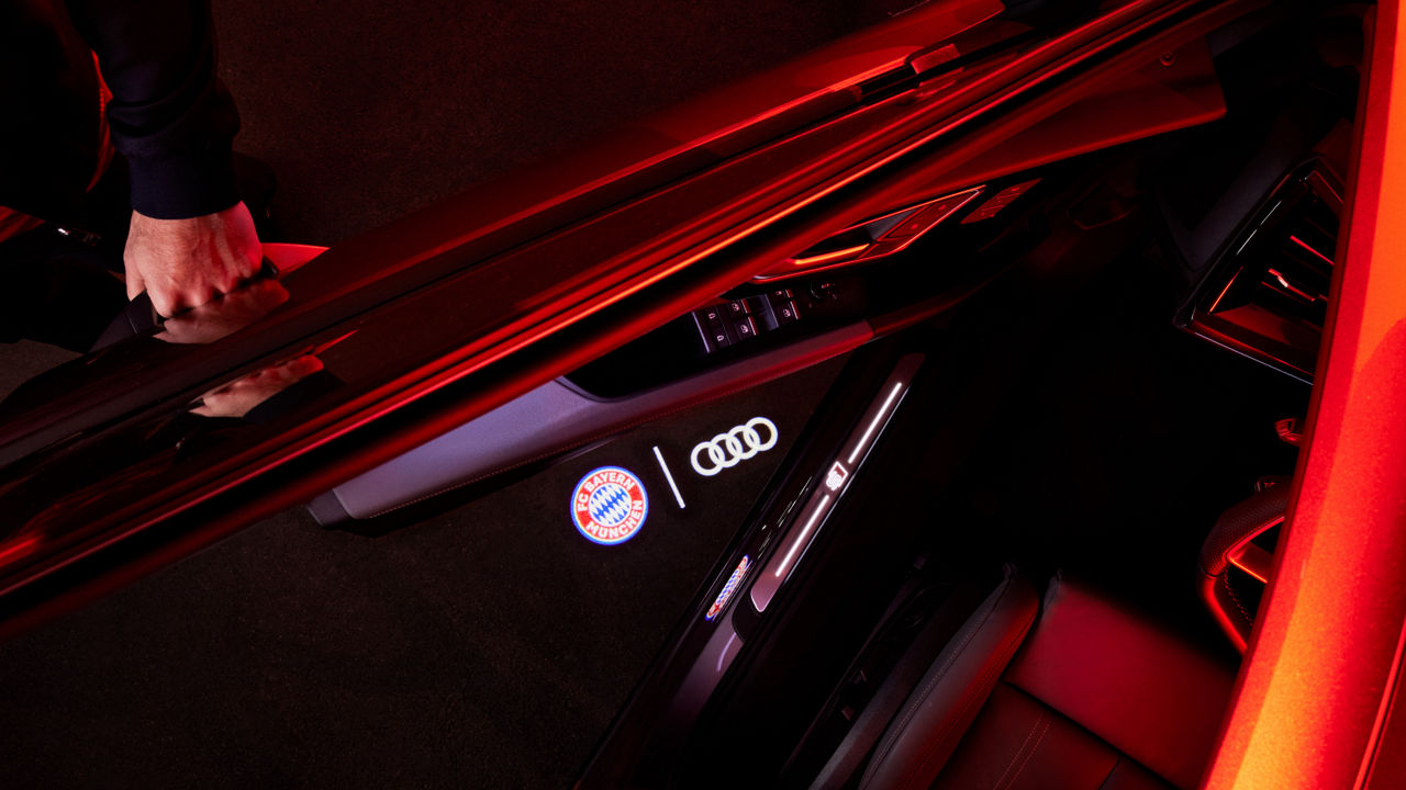 FC Bayern and Audi logo are projected onto the floor under the vehicle door. 