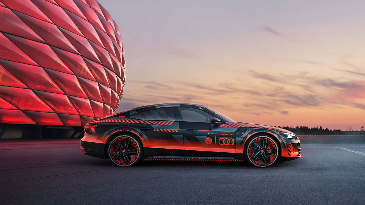 Der Audi RS e-tron GT FC Bayern concept mit roter Sonderfolierung vor der Allianz Arena