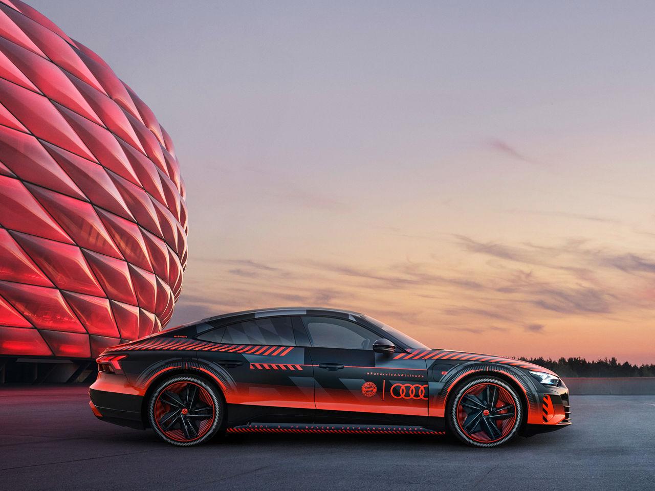 Der Audi RS e-tron GT FC Bayern concept mit roter Sonderfolierung vor der Allianz Arena