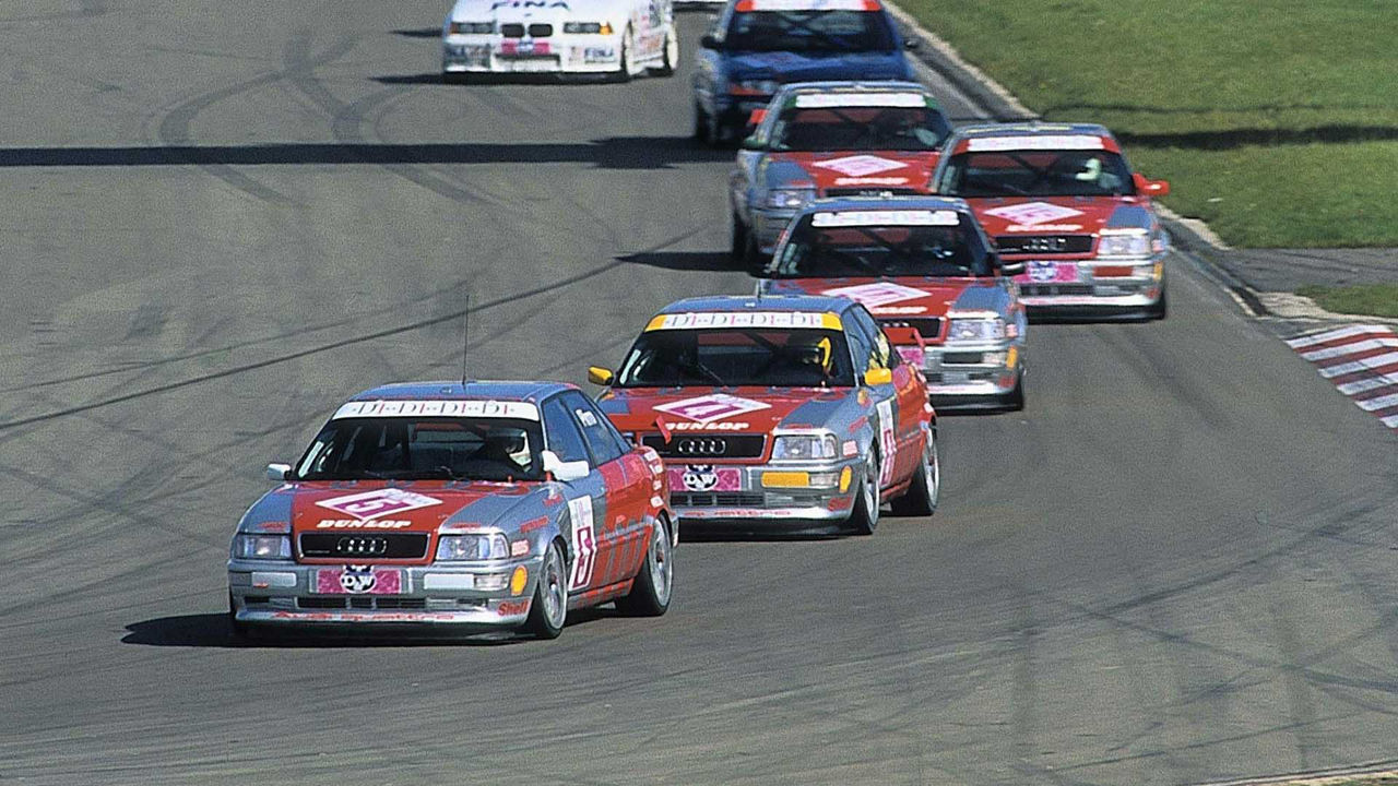 A picture showing five Audi 80 Competition race cars leading a race at the Nürburgring in 1994.