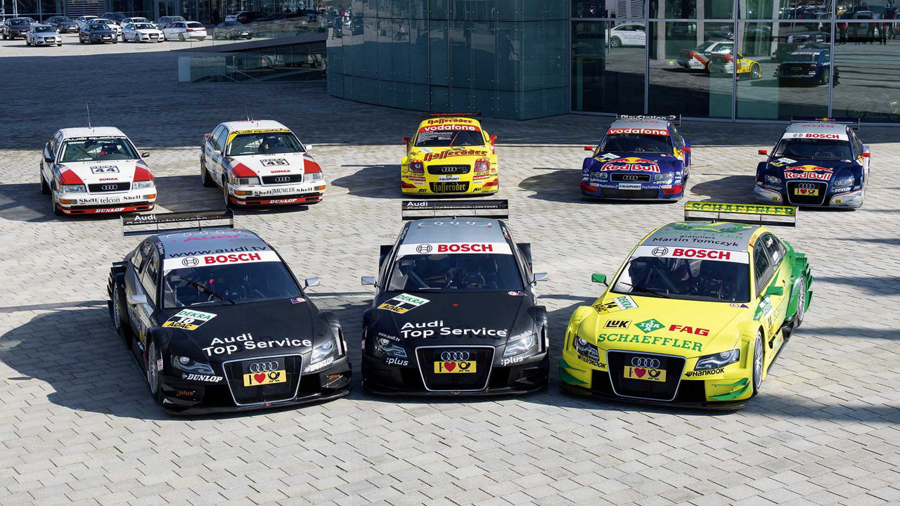 A group picture showing eight Audi race cars that won DTM titles.