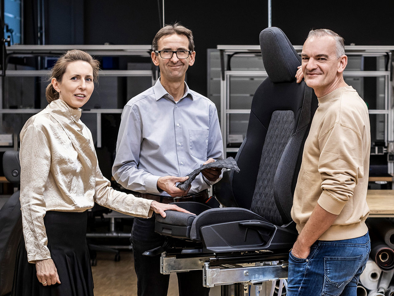 Christine Maier, Jürgen Frank and Günther Ernst in front of an audi car seat
