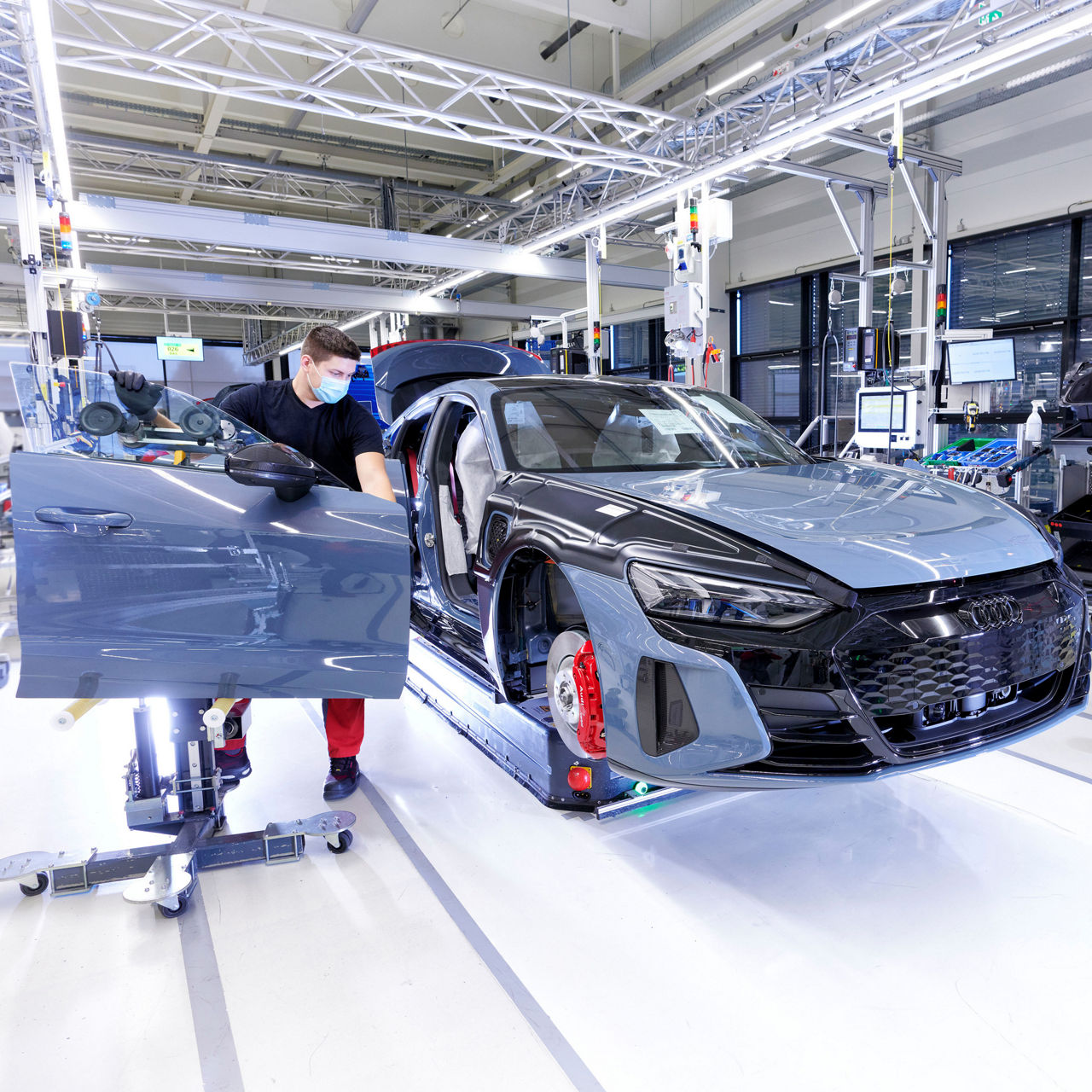 An employee installs a door in production