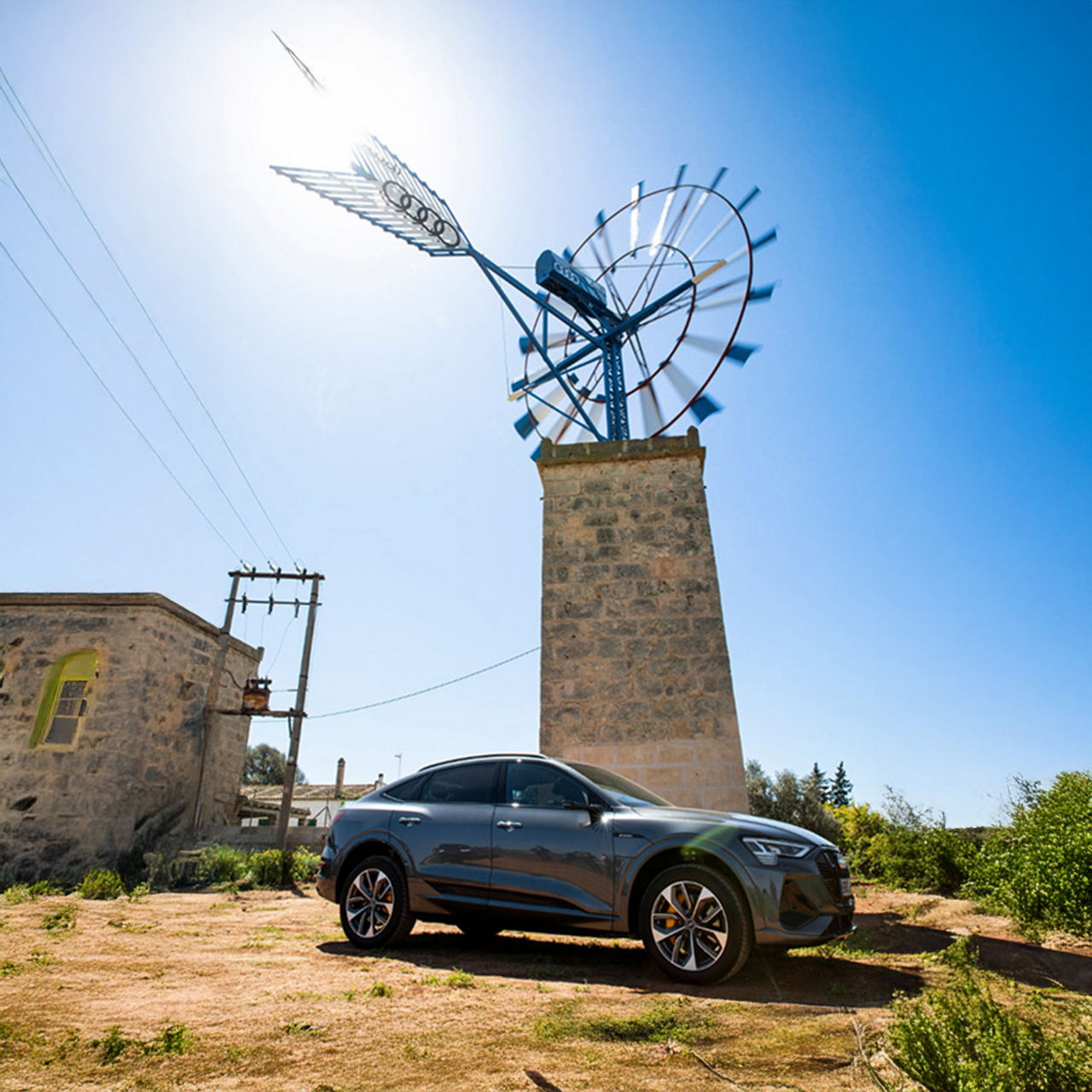 An Audi stands in front of a windmill