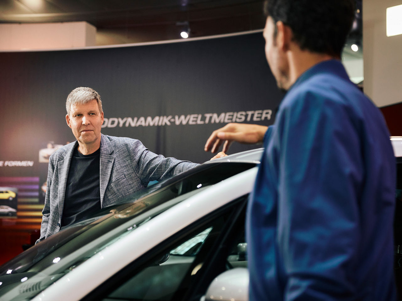 Rüdiger Recknagel and Felix Neureuther look at each other over the roof of an Audi model