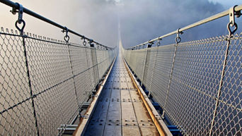 A suspension bridge that leads into the fog