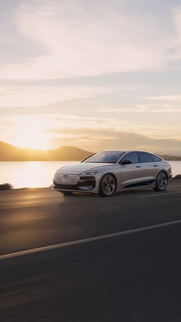 Audi A6 Sportback e-tron performance fährt vor einem Sonnenuntergang