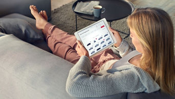 Woman sitting on sofa with tablet