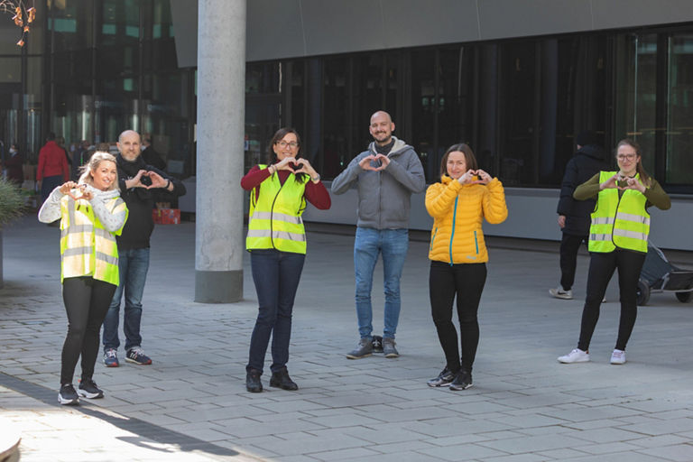 Six people show a heart to the camera with their hands.